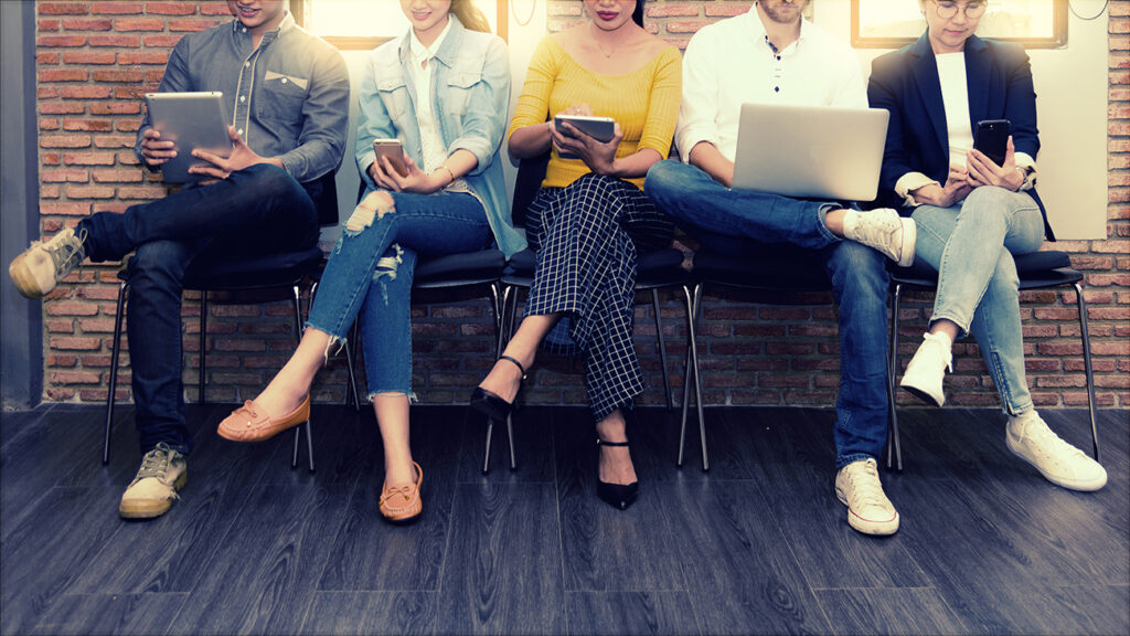 Multiethnic asian business group in casual suit using smart phone, tablet and laptop for working or playing social network and web site in modern office. Business and Technology concept